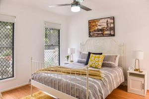 a bedroom with a bed and a ceiling fan at The Arcadia - Entire Luxurious English Cottage With Huge Privacy Near CBD in Springfield Lakes