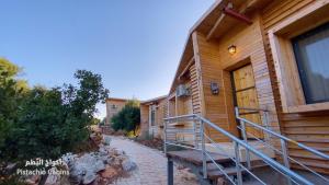 a log cabin with a staircase leading to a door at Ajloun Forest Reserve in Ajloun