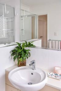 a bathroom with a sink and a potted plant at The Arcadia - Entire Luxurious English Cottage With Huge Privacy Near CBD in Springfield Lakes