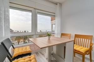 a dining room with a table and chairs and windows at Estudio Fetén Algarrobo Costa in Algarrobo-Costa