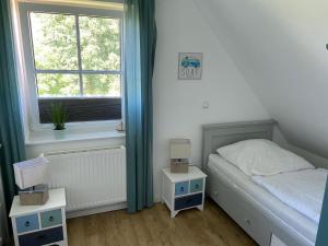 a small bedroom with a bed and a window at Ferienhaus 14 "Gut Tossens" in Tossenserdeich
