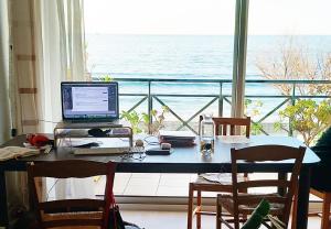 uma secretária com um computador com vista para o oceano em Appartement bord de mer très lumineux 2/4 pers. - Vue inoubliable em Hendaye