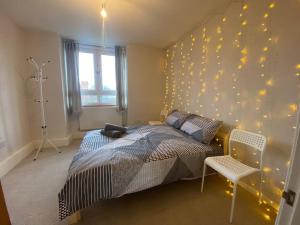 um quarto com uma cama e uma parede com luzes em Flat by Victoria park - with balcony em Londres