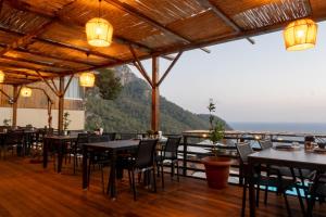 a restaurant with tables and chairs and a view of the ocean at Tree Houses Hotel in Fethiye