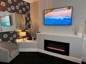 uma sala de estar com lareira e uma televisão de ecrã plano por cima em Sandy Toes : Relaxing Contemporary Victorian Apartment 10 mins to Beach em Torquay