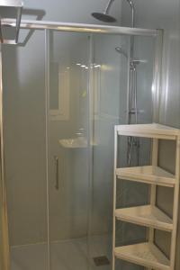 eine Dusche mit Glastür und Regalen im Bad in der Unterkunft Roses Center 6 in Roses