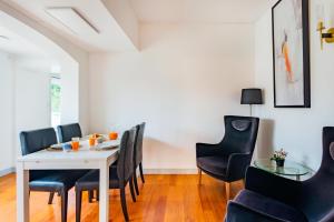 a dining room with a white table and black chairs at Estoril Riviera Apartments in Estoril