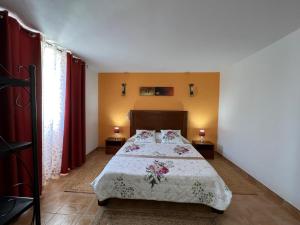 a bedroom with a bed with a white comforter and two lamps at Quinta dos Viegas in Faro
