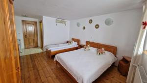 a hotel room with two beds and a bathroom at Pensiunea Brian in Moieciu de Jos
