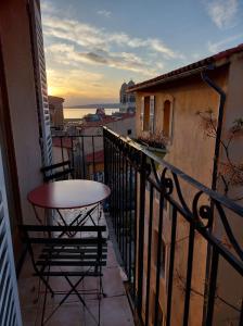 uma varanda com uma mesa e cadeiras num edifício em Love nest with sea view in the heart of the Panier em Marselha