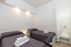 um quarto com 2 camas e uma janela em Melania Holidays Home - Sole Incantatore em Santa Maria Navarrese