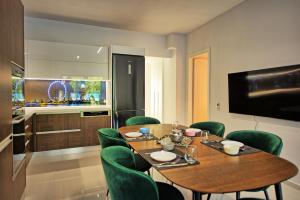 a dining room with a table and green chairs at Casa Cafenio by PosarelliVillas in Nípos