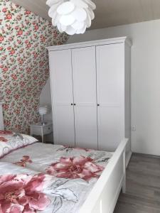 een slaapkamer met een bed en een witte kast bij Ferienwohnung mit Seeblick - a84916 in Jemgum