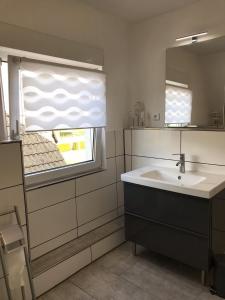 een badkamer met een wastafel en een raam bij Ferienwohnung mit Seeblick - a84916 in Jemgum