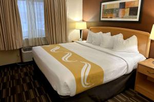 Een bed of bedden in een kamer bij Quality Suites Near West Acres