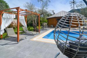 eine Terrasse mit einer Schaukel und einem Pool in der Unterkunft Kayi Villas in Kayakoy