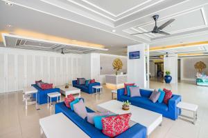 a living room with blue couches and tables at Best Western Patong Beach in Patong Beach