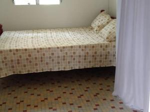 Ce petit lit se trouve dans un dortoir doté de carrelage. dans l'établissement Maison familiale et authentique, à Vieux-Habitants