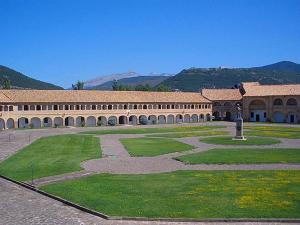 a large building with a courtyard with green grass at Apartamentos Jaca Ciudadela 3000 in Jaca