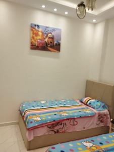 a bedroom with two beds and a picture on the wall at Hurghada's Marina view in Hurghada
