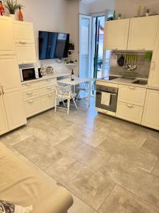 a kitchen with white cabinets and a tile floor at La Terrazza sul Mare [ ☆☆☆☆☆ ] Monterosso in Monterosso al Mare
