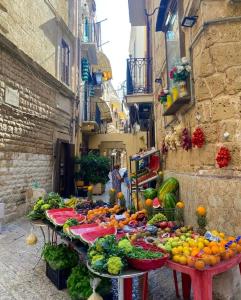 Una exhibición de frutas y verduras en mesas en un callejón. en Casa della Luna, en Bari