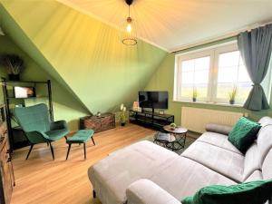 Una sala de estar con un sofá y un televisor. en Ferienwohnung Rabenblick, en Binz