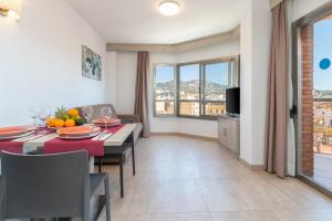 a kitchen and dining room with a table and chairs at Marina Beach Apartaments in Lloret de Mar