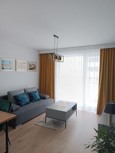 uma sala de estar com um sofá e uma mesa em Apartament nr15 z parkingiem podziemnym em Toruń