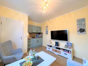 Una sala de estar con un televisor de pantalla plana y una mesa. en Ferienwohnung Rabennest, en Binz