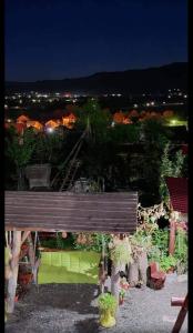 een houten bank die 's nachts in een tuin zit bij Casa Rariana in Călimăneşti