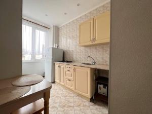 uma cozinha com armários amarelos e um frigorífico branco em Apartments near Arena City em Kiev