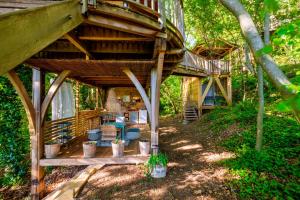 a tree house in the woods with a deck at King Louie and Mowgli in Saint-Paul-de-Vence