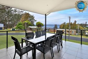 una mesa y sillas en un balcón con vistas al océano en Panorama at Jervis Bay I Pet Friendly I 15 Mins to Hyams Beach en Bewong