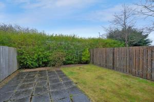 a garden with a wooden fence and a yard at Caledonia Newhills Apartment in Aberdeen