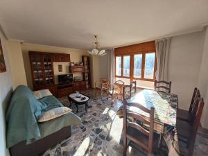 sala de estar con sofá, mesa y sillas en Casa Rural Sol y Luna Apartamentos, en Munébrega