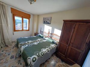 um quarto com uma cama e um armário de madeira em Casa Rural Sol y Luna Apartamentos em Munébrega