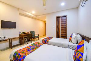 Habitación de hotel con 2 camas y escritorio en FabHotel Royal Crystal, en Bhubaneshwar