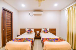 um quarto com 2 camas e lençóis coloridos em FabHotel Royal Crystal em Bhubaneshwar