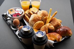 a tray of food with bread and pastries and drinks at Olvia Suites in Athens