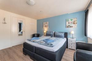 1 dormitorio con cama y pared azul en B&B De Goede Tijd en Thorn