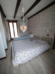 1 dormitorio con 1 cama grande y suelo de madera en La Ghianda con terrazza, en Cossogno