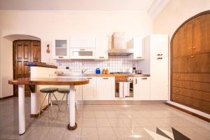 cocina con armarios blancos y mesa de madera en L'Olea casa vacanze en Campobasso
