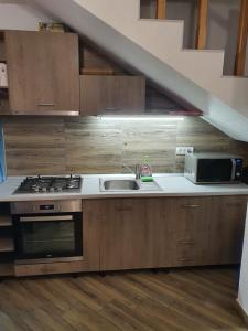 a kitchen with a stove and a sink and a staircase at Casa Miruna & Noris in Bran
