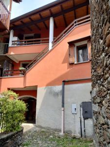 un edificio naranja con puerta y ventana en La Ghianda con terrazza, en Cossogno