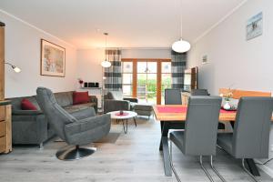 ツィングストにあるFerienpark Freesenbruch Wohnung 4 3 - Inseltreffのテーブルと椅子とソファのあるリビングルーム