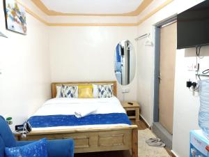 a small bedroom with a bed and a tv at Essie Studios Naivasha CBD in Naivasha