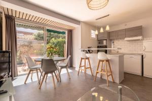 a kitchen and dining room with a table and chairs at Résidence Maminotte in La Teste-de-Buch