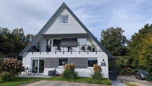 a white house with a gambrel roof at MiBa Mare Ferienwohnung "Sol" in Scharbeutz