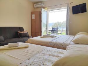 a living room with two beds and a couch at Apartments Draženka in Neum